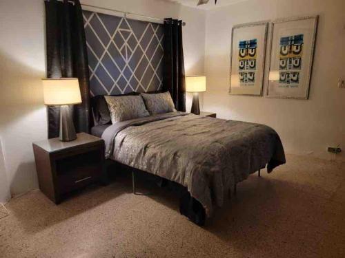 Un dormitorio con una cama grande con dos lámparas. en La marquesina guess home, en Loiza