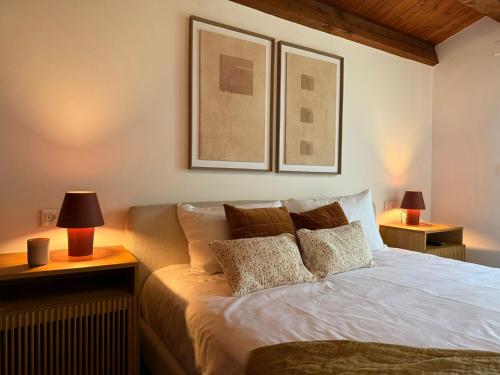 a bedroom with a bed with two lamps and two pictures at Casa Petra in Morillo de Monclús
