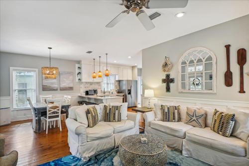 a living room with two couches and a kitchen at Sans Souci by 30A Escapes in Seacrest