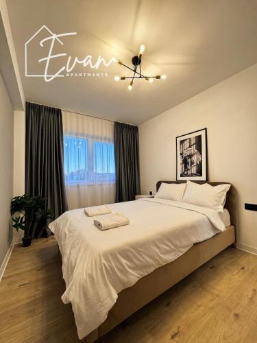 a bedroom with a large bed with white sheets at Luxury Park View Apartment by Evan Apartments in Şelimbăr