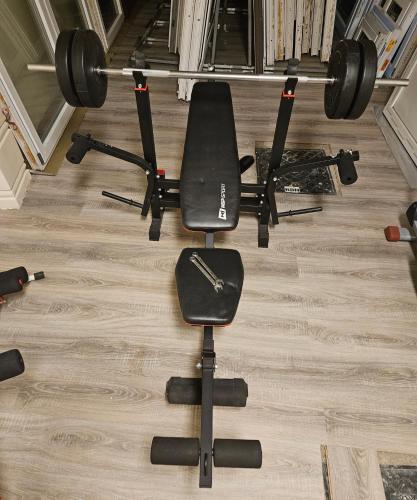 a gym with a bench and weights at Modern and bright light room 