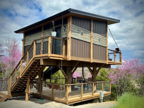 a tree house sitting on top of a wooden deck at "The 19th Hole" Luxury Treehouse w Golf Views & Private 20ft Slide - 10 Miles from Dollywood in Catlettsburg