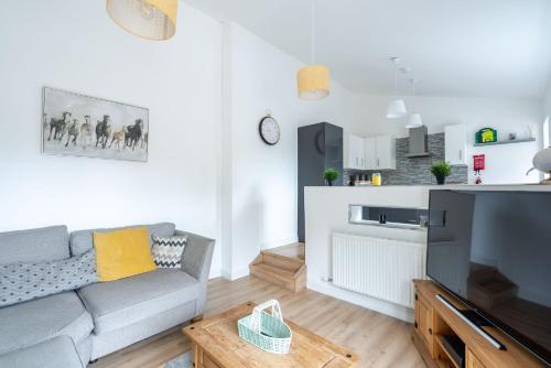 a living room with a couch and a large television at Fife coastal corner in Buckhaven
