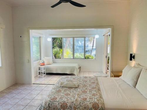 een slaapkamer met een groot bed en een raam bij Maree's Beachfront House - Free Internet in Arorangi