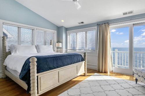 een slaapkamer met een bed met uitzicht op de oceaan bij Sunrise to Sunset Waterfront Retreat in Milford