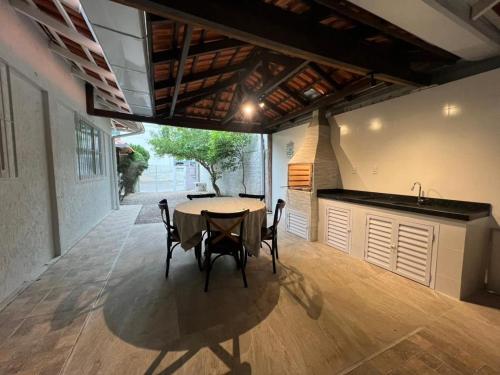 eine Küche und ein Esszimmer mit Tisch und Stühlen in der Unterkunft Residencial Elsa Tarcila in Bombinhas