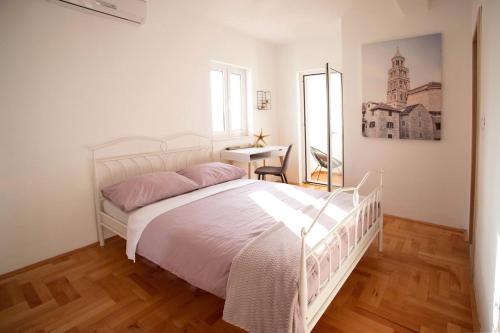 ein Schlafzimmer mit einem Bett, einem Schreibtisch und einem Spiegel in der Unterkunft Meerblick Apartment mit großer Sonnenterrasse für 6 Personen in Sumartin