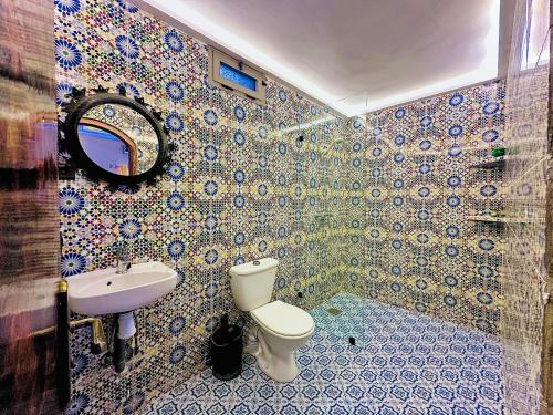 a bathroom with a toilet and a sink and a mirror at La Petite Kasbah in Zagora