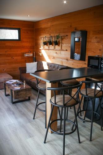 a living room with a couch and a table at Chalet moderne, Jacuzzi & Cinéma in Saint-Coulitz