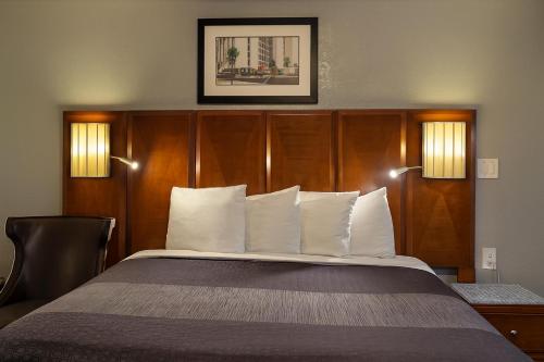 a bed with white pillows in a hotel room at Mountain Star Inn in Cedar City
