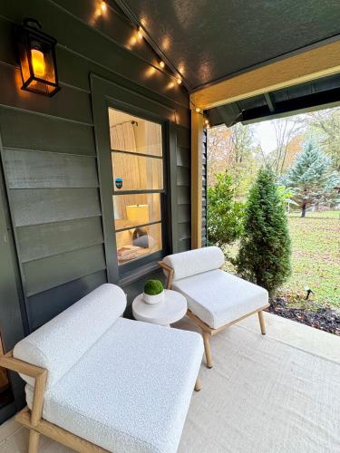 two white chairs and a table on a porch at Farmhouse at Montaluce Winery-2 Restaurants- Fast WIFI-Free Park-Hike-Weddings in Dahlonega