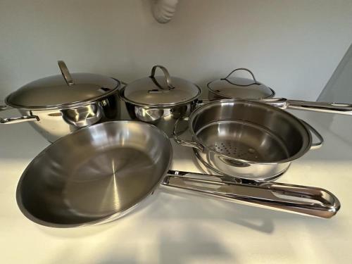a group of four metal pots and pans on a counter at Apartamento Novo - Conforto no Saguaçú! in Boa Vista