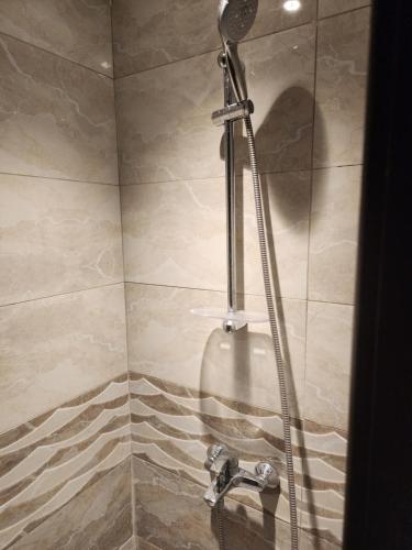 a shower with a shower head in a bathroom at اصول الجوهرة العزيزية Asoul Al Jawhara Al Azizia in Al ‘Azīzīyah