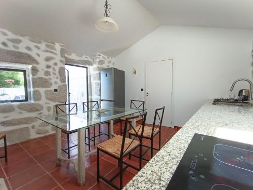 a kitchen with a glass table and some chairs at Casa do Velho Vinhateiro in Gagos
