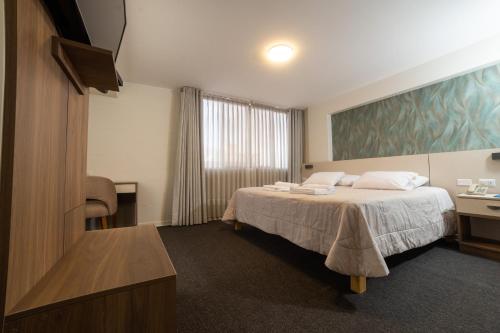 una habitación de hotel con una cama y un televisor en VIP Hotel, en Ilo