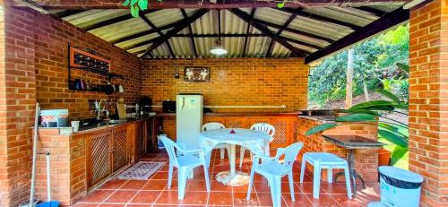 uma cozinha com mesa e cadeiras em uma cozinha em Pousada dos Chalés - Araras em Araras Petropolis