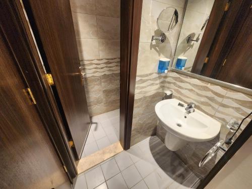 a bathroom with a shower and a white sink at اصول الجوهرة العزيزية Asoul Al Jawhara Al Azizia in Al ‘Azīzīyah