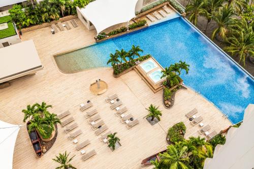 Una vista aérea de una piscina con sillas y árboles. en Hotel Irotama Reservado, en Santa Marta