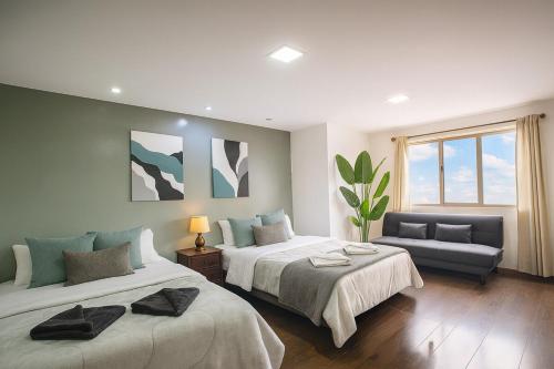 una grande camera da letto con due letti e un divano di Emerald Retreat con Jacuzzi y BBQ a Cuenca