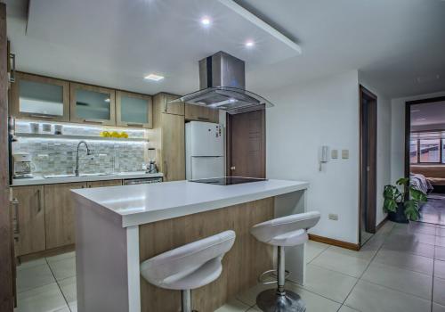 una cucina con bancone e due sgabelli di Emerald Retreat con Jacuzzi y BBQ a Cuenca