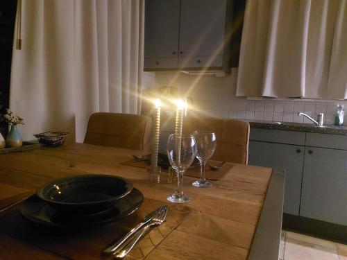 a table with a candle and wine glasses on it at Landelijk gastenverblijf met zwembad en sauna in het hart van Friesland in Akkrum