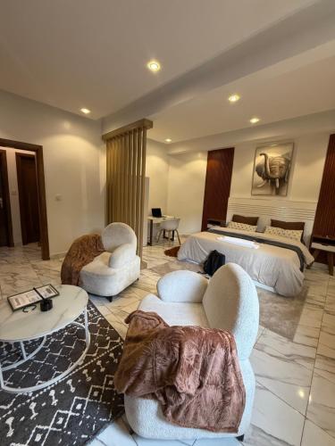 une chambre d'hôtel avec deux lits et des chaises et un lit dans l'établissement logement luxueuse au pieds du monument de la renaissance africaine, à Dakar