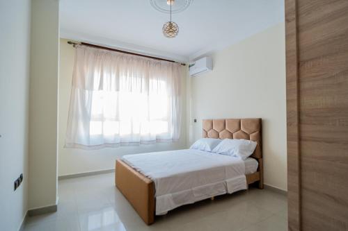 a bedroom with a bed and a window at RESIDENCE Al SALAM in Tangier