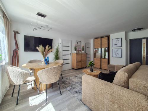 a living room with a couch and a table at Przystanek Karpacz - Apartament Rejkiawik in Karpacz