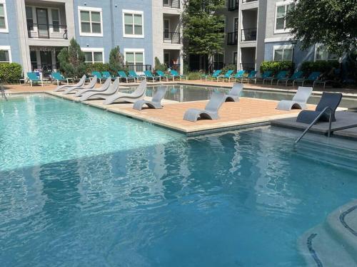 a swimming pool with lounge chairs in a building at Centrally-Located 1BR Suite with Resort Pool View in Frisco
