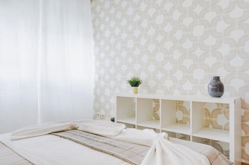 1 dormitorio con cama blanca y pared en Quartos da Expo, en Lisboa