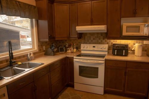a kitchen with a white stove top oven next to a sink at Mi Light House 米拉 in Yellowknife