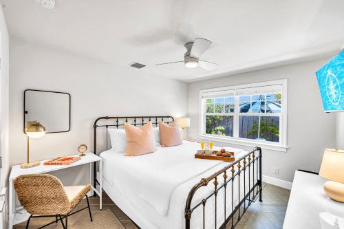 ein Schlafzimmer mit einem Bett und einem Stuhl und einem Fenster in der Unterkunft Enchanting Home Beach Proximity Jacuzzi Serenity Key Two RESlDENCES in Delray Beach