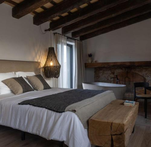 a bedroom with a large bed and a bath tub at Mas Escarrà in Caldes de Malavella