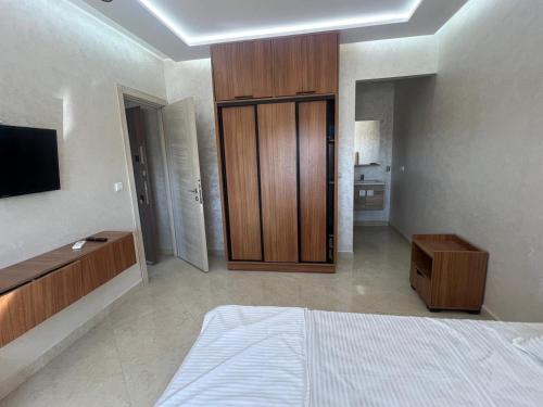 a bedroom with a bed and a wooden cabinet at Résidence Saadia, Khouribga in Khouribga