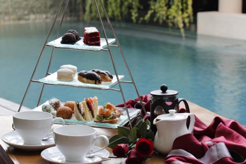a table with two plates of pastries and coffee cups at Berry Amour Romantic Villas in Seminyak