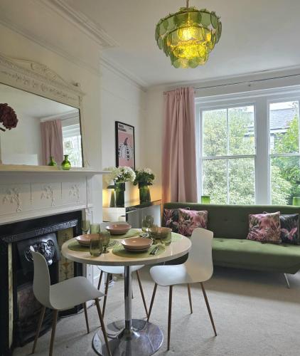 a living room with a table and a green couch at Boutique Accommodation in London