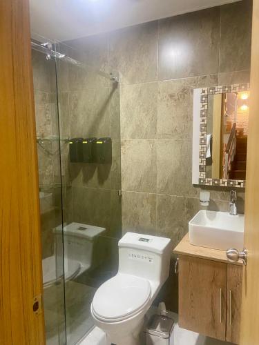 a bathroom with a toilet and a shower and a sink at House in Miraflores Cuenca in Cuenca