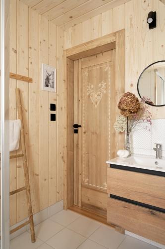 a bathroom with a sink and a door with a mirror at Stylowa Chata in Zakopane