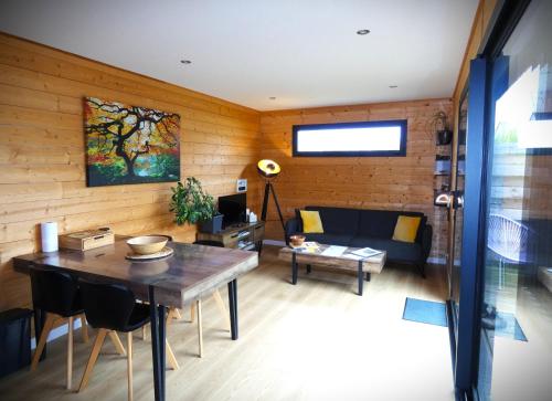 a living room with a table and a couch at Cottage chaleureux avec Sauna & Jacuzzi in Saint-Coulitz