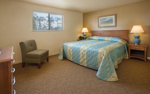 a hotel room with a bed and a chair at WorldMark Surfside Inn in Ocean Park