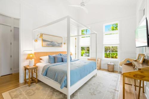 - une chambre blanche avec un lit à baldaquin blanc dans l'établissement Barefoot Bungalow by Stay on 30a, à Seagrove Beach