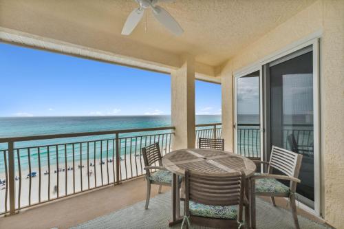 a table and chairs on a balcony with a view of the beach at HP 45W What the Heck by 30A Escapes in Rosemary Beach