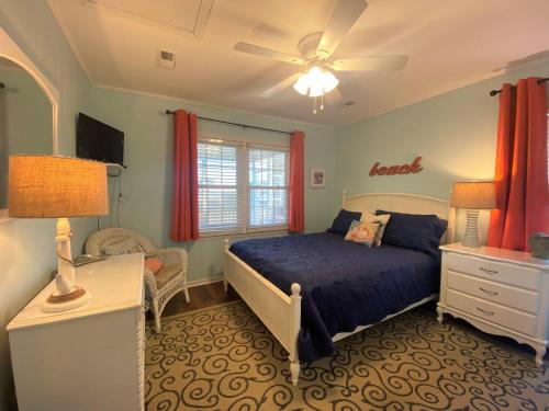 a bedroom with a bed and a desk and a ceiling fan at Sand In My Shoes in Edisto Island