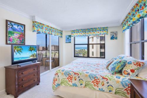 シエスタ・キーにあるGulf and Bay Club- C611のベッドとテレビと窓のある寝室