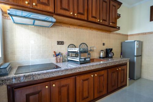 a kitchen with wooden cabinets and a counter top at RESIDENCE Al SALAM in Tangier