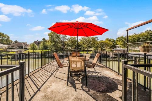 eine Terrasse mit Tisch und Stühlen und einem Sonnenschirm in der Unterkunft Lakefront Dock & Fire Pit Book with Family for Wurstfest Now in McQueeney
