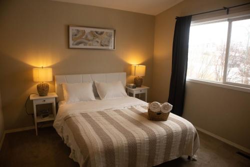 a bedroom with a bed with two pillows and a window at Mi Light House 米拉 in Yellowknife