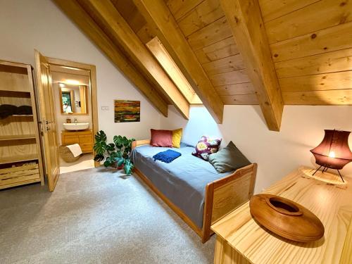 a bedroom with a bed in a room with wooden ceilings at apartmány V Lese in Bedřichov