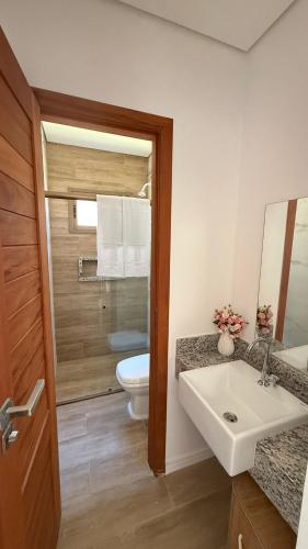 a bathroom with a white sink and a toilet at AP 104 com Piscina e Churrasqueira - Canoas Flecheiras in Trairi