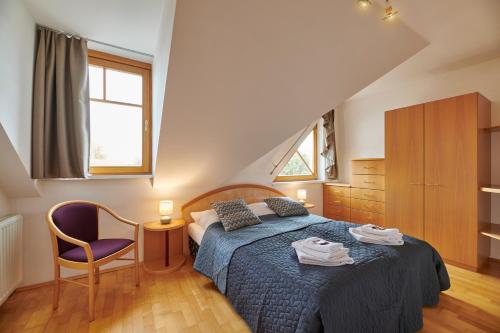 um quarto com uma cama, uma cadeira e uma janela em DAS BURGENNEST, Bademantelgang zur Therme Lutzmannsburg, Garten, Parkplatz, Verpflegung auf Anfrage em Lutzmannsburg